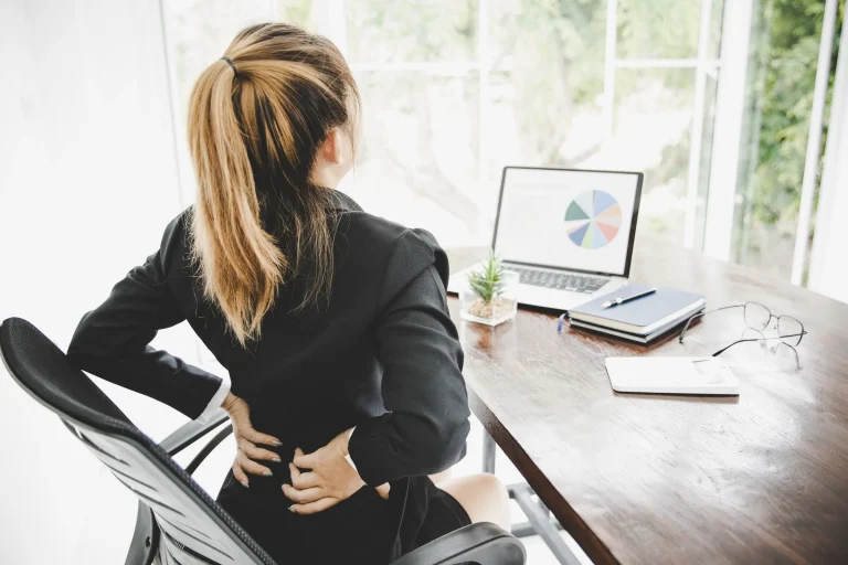 Low back pain at a desk, the posture it most often builds in